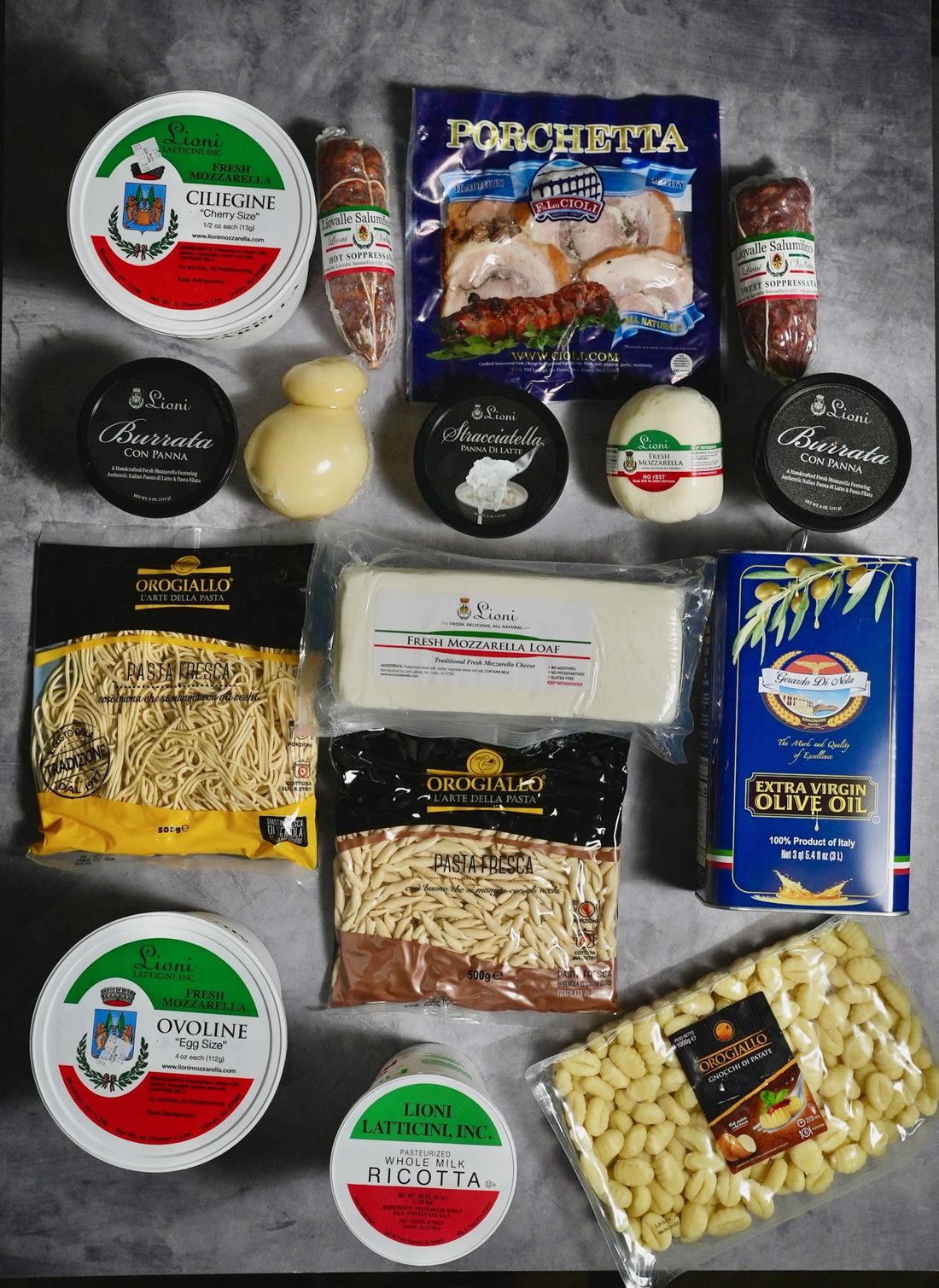 A full order laid out: Lioni ciliegine and ovoline, burrata con panna, stracciatella, fresh mozzarella loaf, whole-milk ricotta, Cioli porchetta and soppressata, Oro Giallo fresh pasta and gnocchi, Gerardo Di Nola olive oil.